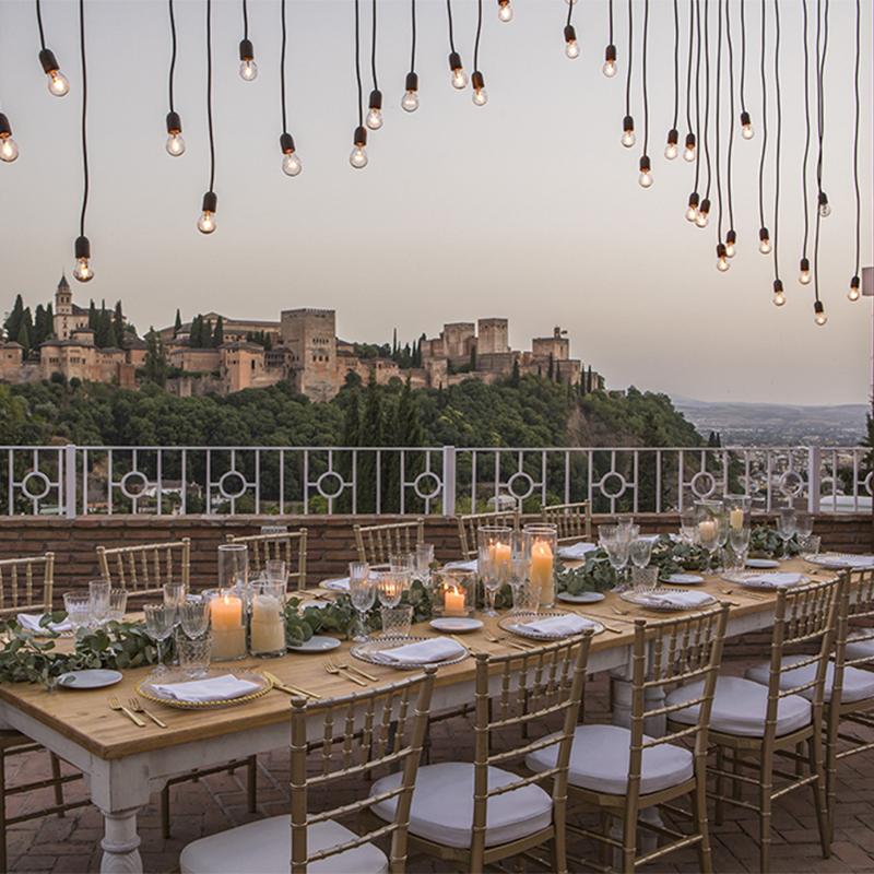 Mesa al aire libre preparada para una boda en El Camborio, con elegantes detalles y vistas panorámicas de la Alhambra de Granada