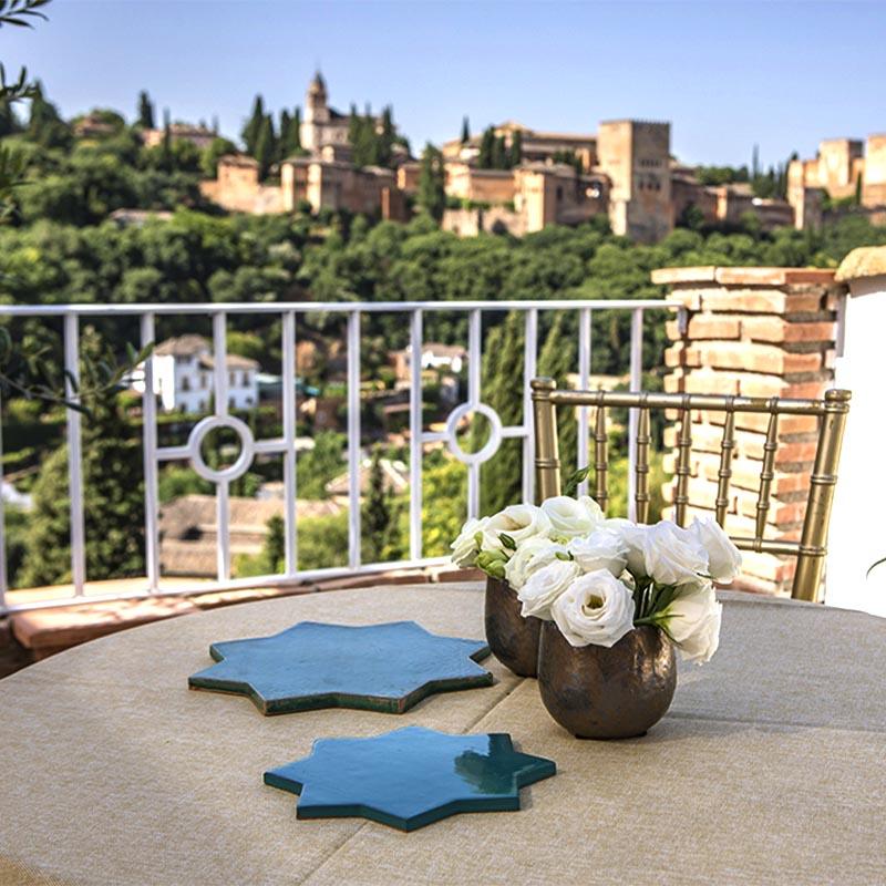 elcamborio-eventos-sociales-granada-12 Mesa al aire libre preparada para una boda en El Camborio, con elegantes detalles y vistas panorámicas de la Alhambra de Granada