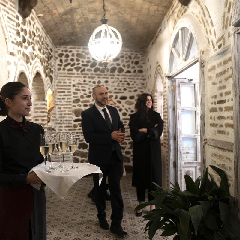Equipo de camareros dando la bienvenida a los novios con dos copas de cava en la zona de la cueva de El Camborio.