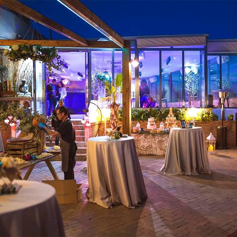 elcamborio-eventos-sociales-granada-19 Montaje de la zona de cóctel para una boda en la terraza de El Camborio, con el equipo organizando y la iluminación decorativa preparada.
