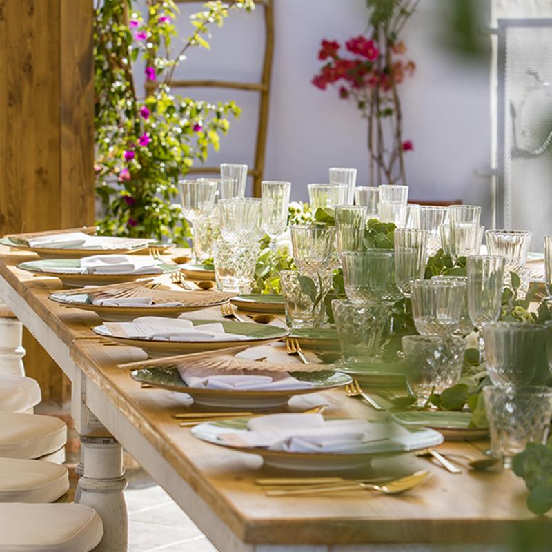 elcamborio-eventos-sociales-granada-25 Detalle del menaje en una mesa alargada para boda en El Camborio, con vajilla elegante y decoración en tonos blancos y verdes