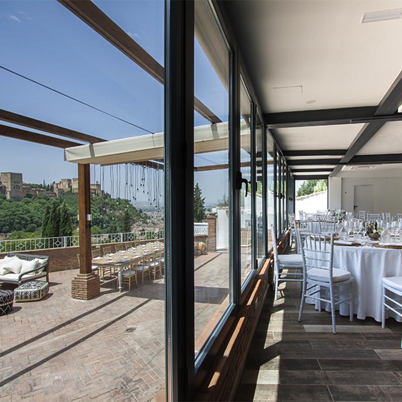 elcamborio-eventos-sociales-granada-31 Vista del salón interior y la terraza exterior de El Camborio, ambos montados y decorados para un evento corporativo.
