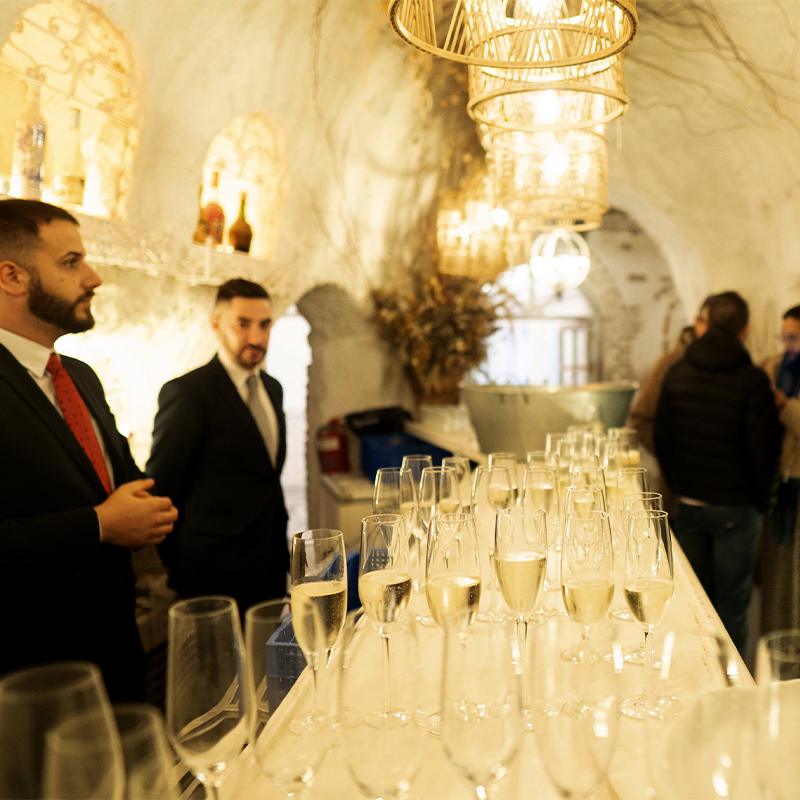 Interior de la barra en la cueva de El Camborio durante un evento corporativo, con copas de cava listas para servir a los invitados.