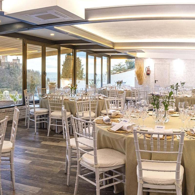eventos-corporativos-elcamborio-granada-15 Salón interior de El Camborio preparado para un evento, con mesas y sillas elegantemente dispuestas y decoración cuidada.