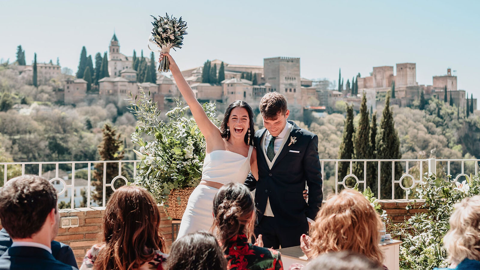 Novios recién casados en el altar de El Camborio, en la terraza, con la Alhambra de Granada al fondo.